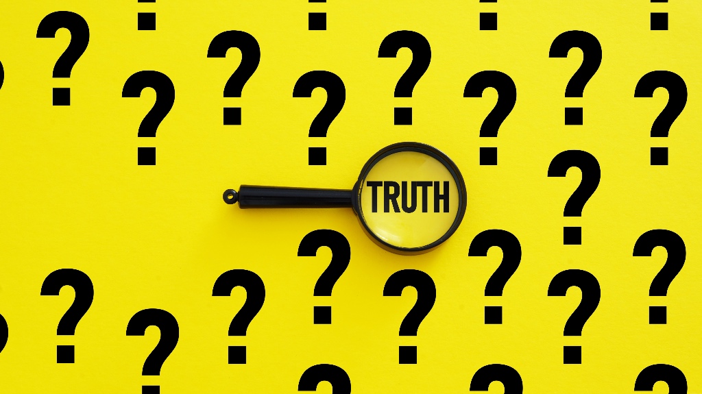 question marks with the word truth in a magnifying glass
