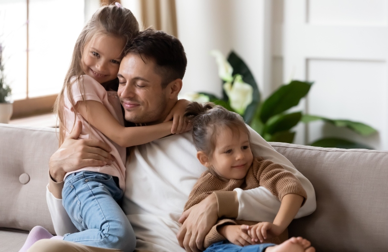 Pleased dad sit on couch with kids