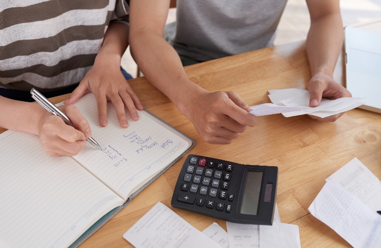 family gathered together at wooden table and keeping records of expenses