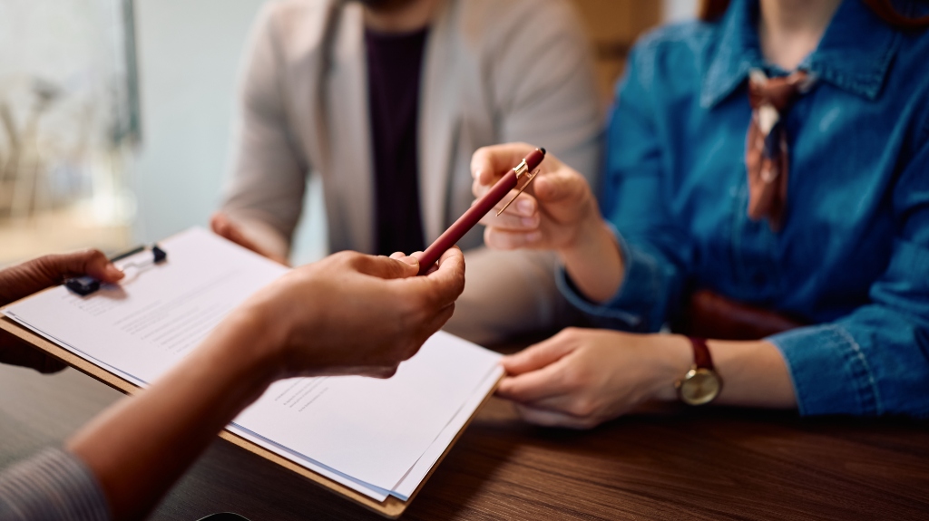 Lawyer is giving a pen to the clients